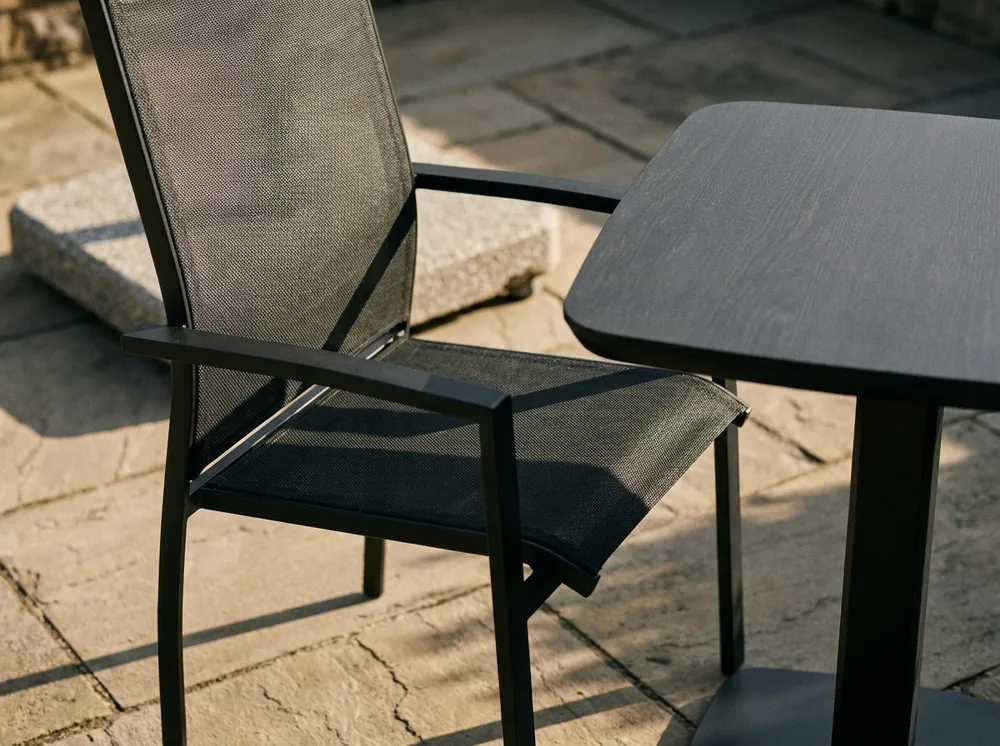 Detail stohovací židle a stolu na kamenné terase